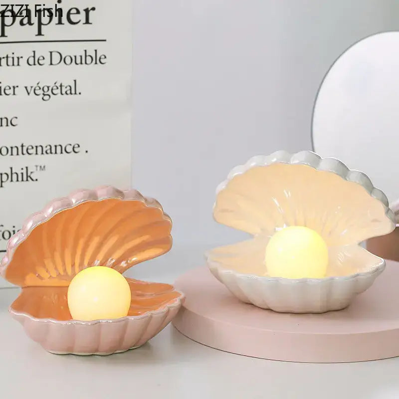 Two ceramic clamshell nightlights in pink and off-white with glowing orbs for modern lamp desk decoration