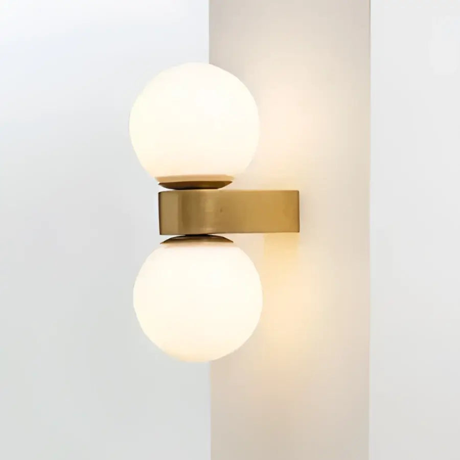 Modern wall lamp with two pink and orange glass ball led frosted shades on a brass decorbites glass ball base