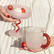 Modern pink and red glass mug set with pink frosted dessert bowl and matching mug featuring bold red handles