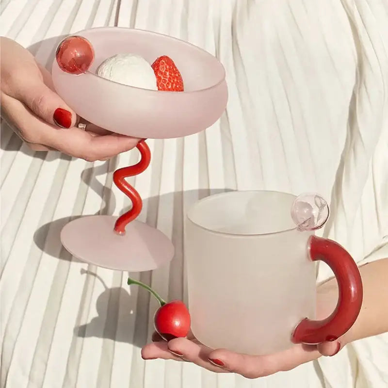 Modern pink and red glass mug set with pink frosted dessert bowl and matching mug featuring bold red handles