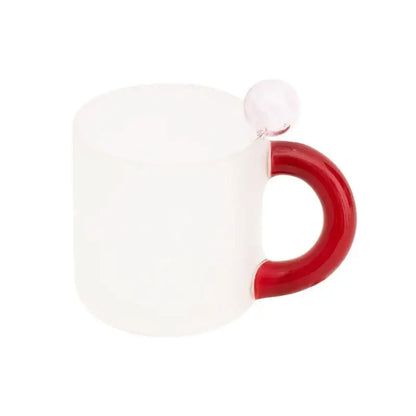 A frosted white glass mug with a glossy red handle and clear spherical accent in a modern glass mug set