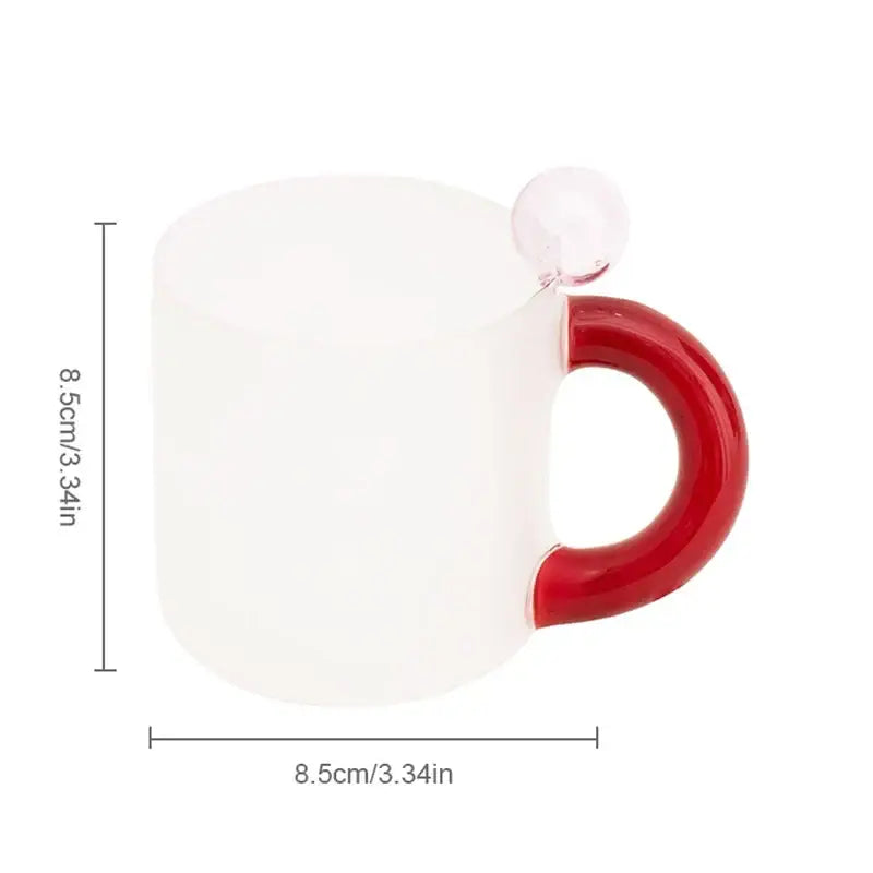 A frosted white ceramic mug with a glossy red handle and clear glass sphere from a modern pink and red glass mug set