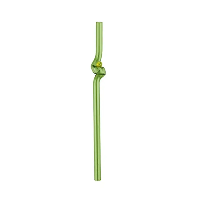 A translucent green glass straw with a decorative knot and yellow bead accent paired with a modern pink and red glass mug set