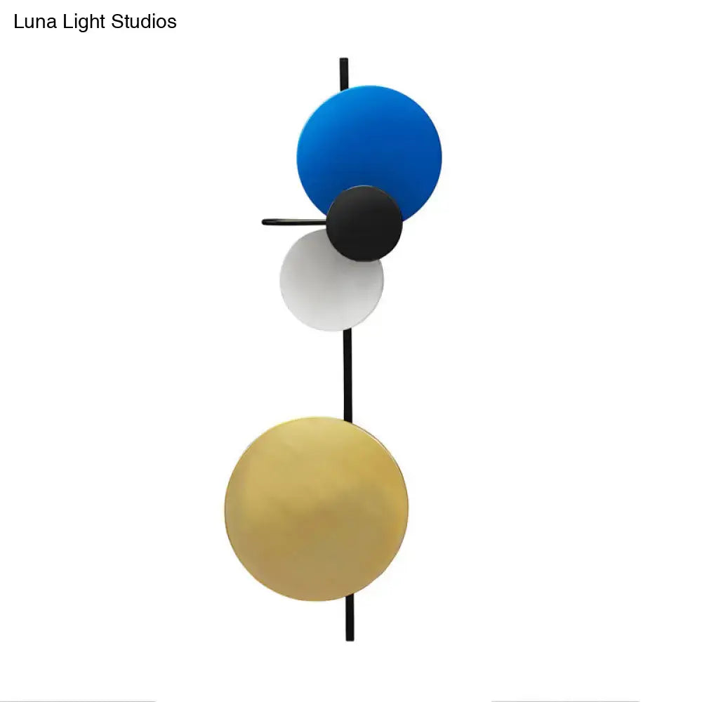 Modern geometric circular wall mount light with bold blue, black, white, and gold discs for living room use
