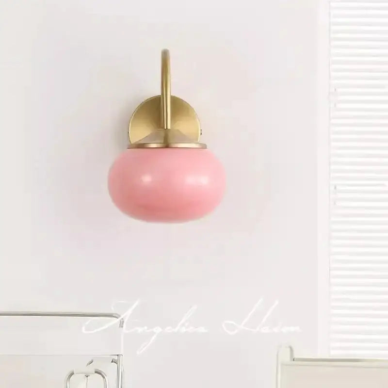 A soft pink glossy ceramic glass ball wall lamp with brass mount for modern living room decorbites lighting