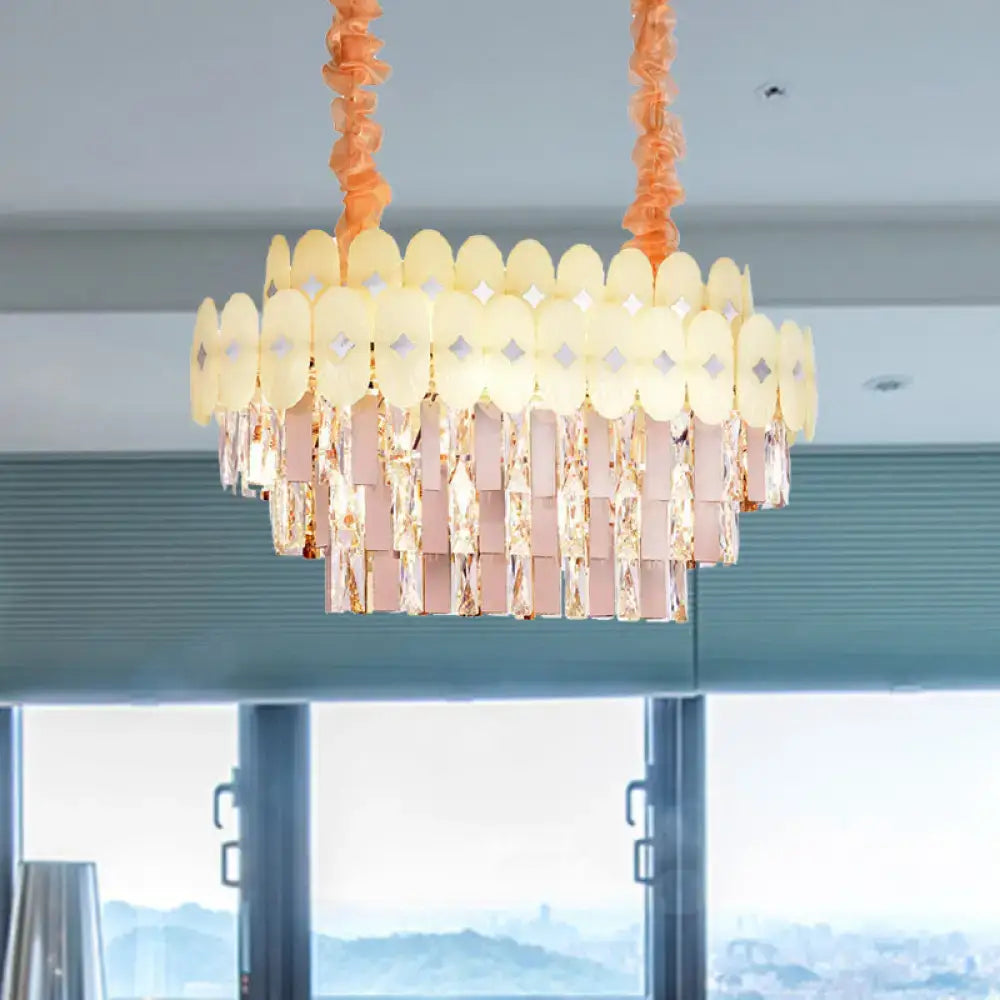 A modern dining room pendant chandelier with clear crystal pinkish-gold prisms and yellow oval glass discs