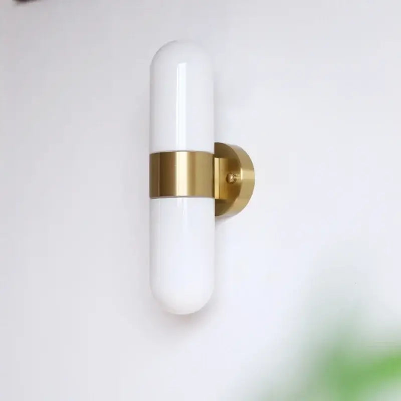 A sleek white frosted glass vanity mirror light with polished brass accent and mounting plate for bathroom use