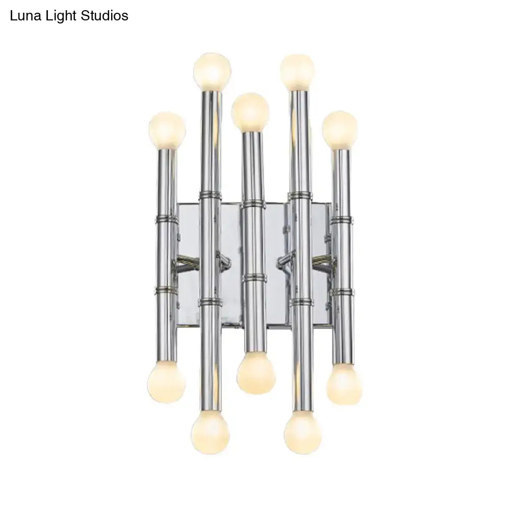 Modern polished gold wall sconce with five slender metal tubes shaped like bamboo holding frosted globe bulbs