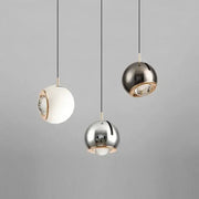 Three modern spherical pendant lights with polished metallic finish and gold-toned accents adjustable angle decorbites pendant light