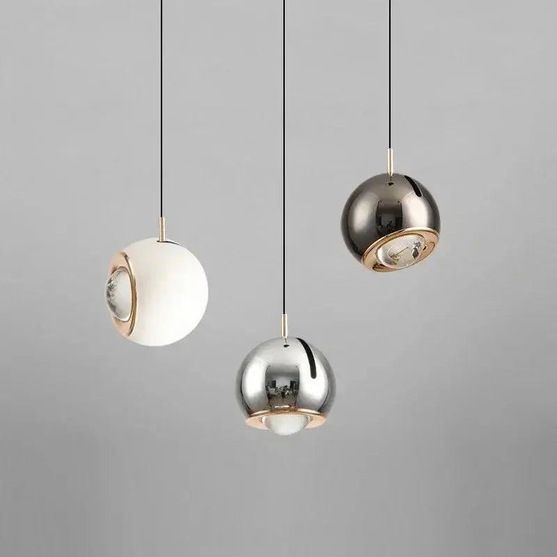 Three modern spherical pendant lights with polished metallic finish and gold-toned accents adjustable angle decorbites pendant light