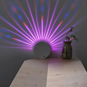 Modern style circular led wall lamp casting vibrant purple and blue radial beams for bedroom decor
