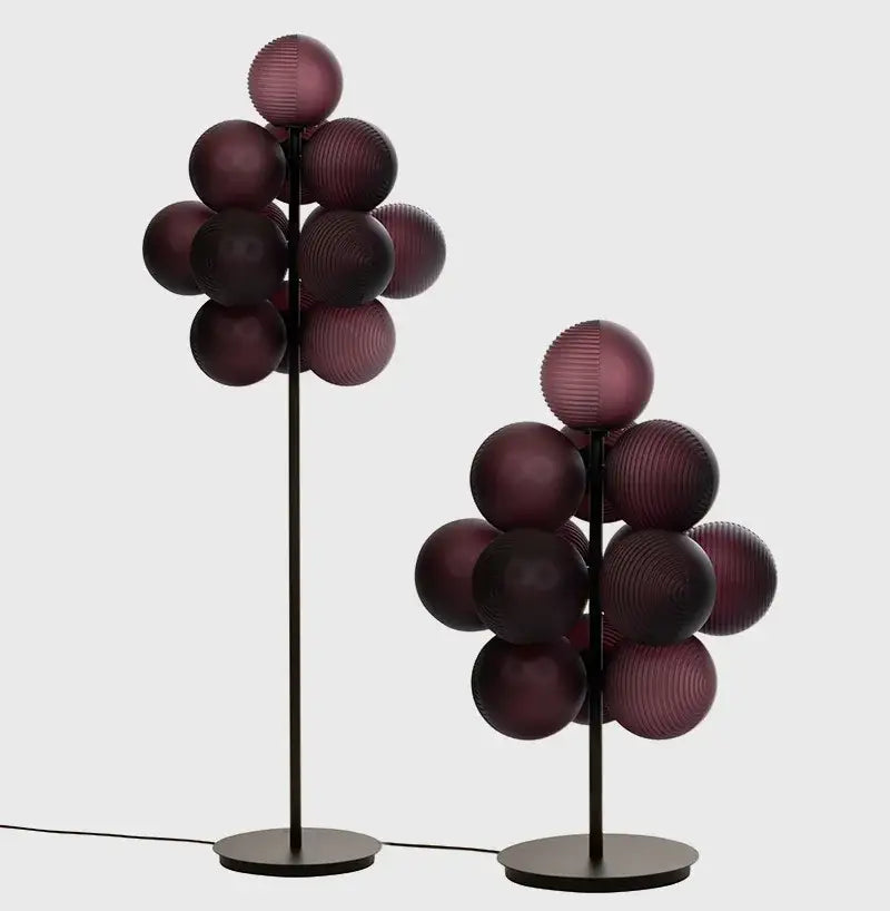 Two modern floor lamps with black metal stems and deep purple decorbites glass bubble clusters for living room use