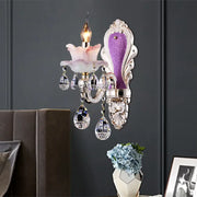 Modern purple and silver crystal wall sconce with a pink floral glass shade for elegant bedroom lighting
