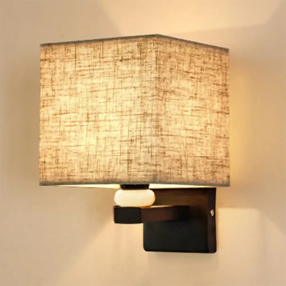 Modern rectangle wall light with square beige fabric shade and off-white ceramic faux jade decor mounted on dark wood sconce