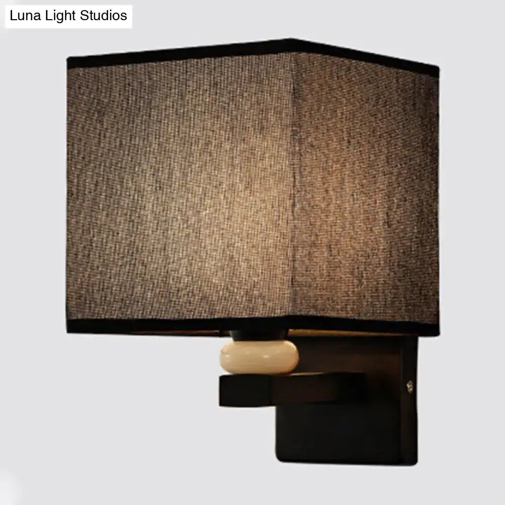 Modern rectangle wall light with textured brown fabric shade black trim and off-white faux jade decor accent for bedroom