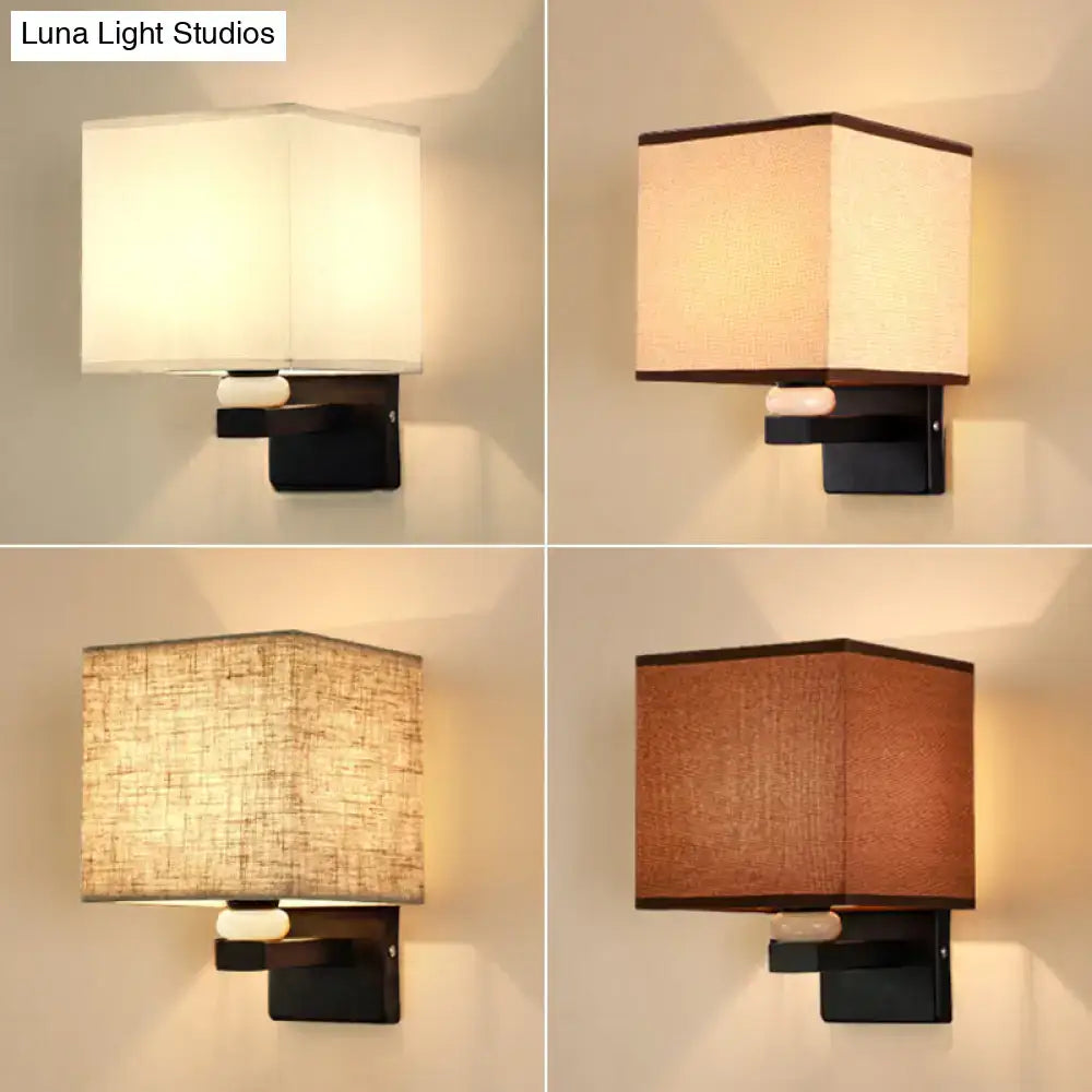 Modern rectangle fabric shade wall light with black metal base and earthy tones fabric shade featuring faux jade decor