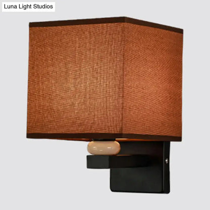 Modern rectangle wall light with brown fabric shade black metal base and off-white ceramic faux jade decor accent