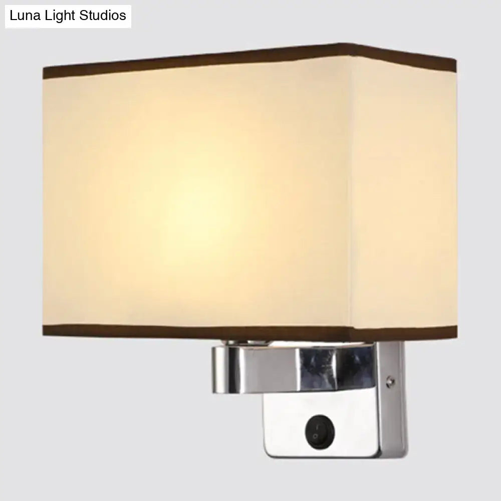 Modern rectangular chrome wall sconce with white beige fabric shade and dark brown trim for bedroom lighting