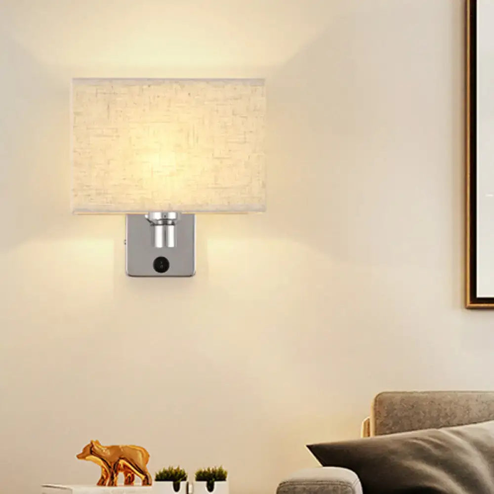 Modern rectangular chrome wall sconce with white beige fabric shade and silver metal base for bedroom lighting