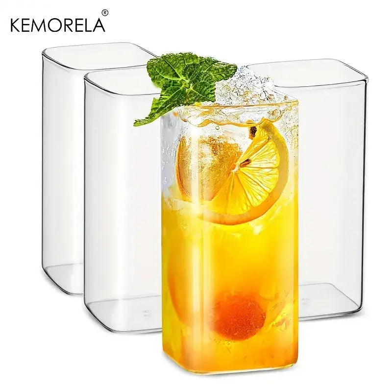 Modern rectangular clear glass highball glasses set with vibrant yellow beverage garnished with lemon and mint leaves