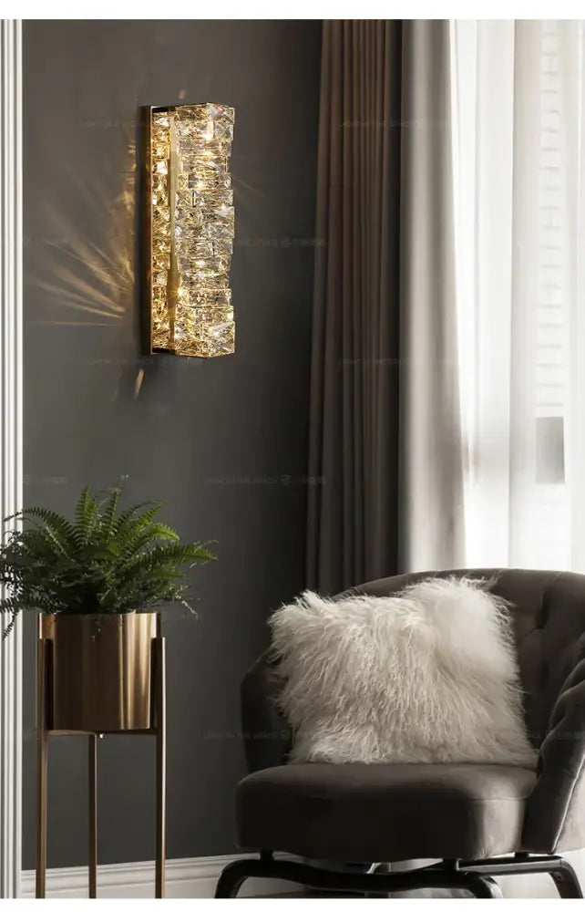 Gold-toned modern rectangular decorbites crystal wall lamp with textured faceted design for bedroom use
