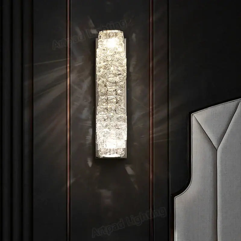 A modern rectangular crystal wall lamp with textured glass panels emitting warm light for bedroom decorbites wall lamp