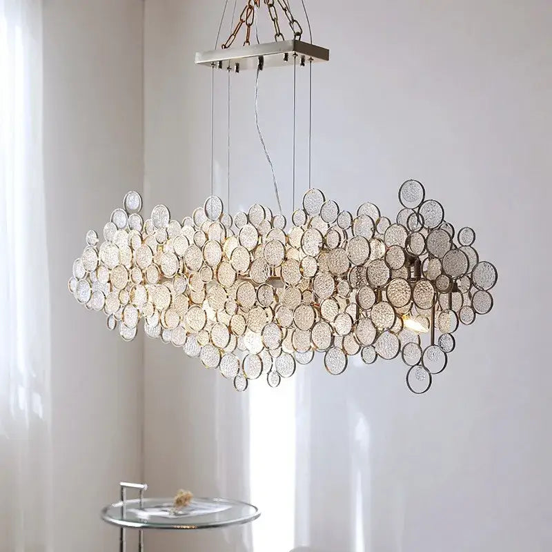 A modern rectangular glass led chandelier with clear textured glass discs and a sleek metallic frame for living rooms