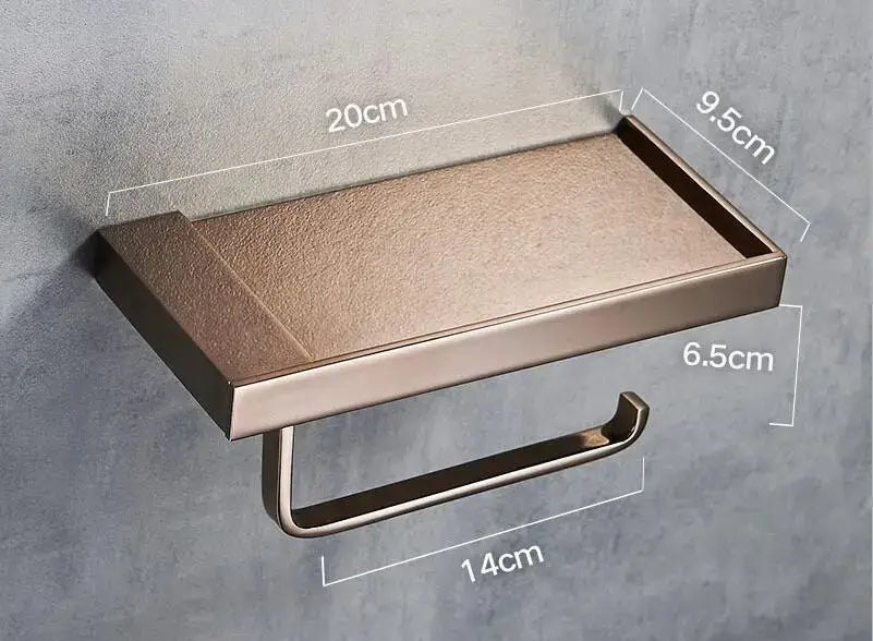 Modern rectangular bronze-finished metal toilet paper holder with textured top surface and integrated shelf for bathroom
