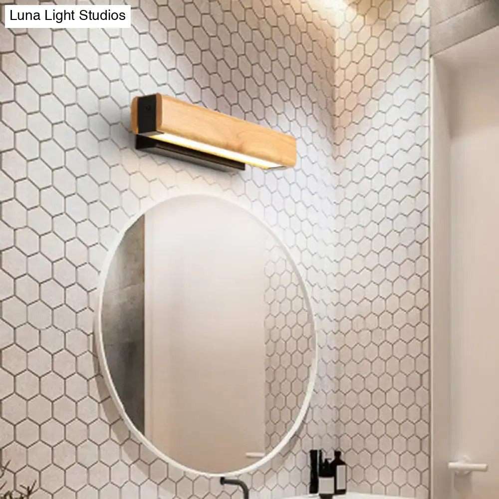 Modern rectangular wood led sconce with light wood finish and black metal accents emitting warm bathroom vanity light type