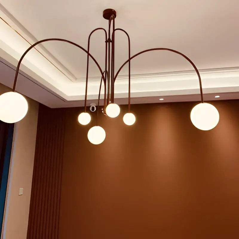 Modern red and white branch glass pendant lights with bronze-toned curved metal arms and frosted globe decorbites branch glass