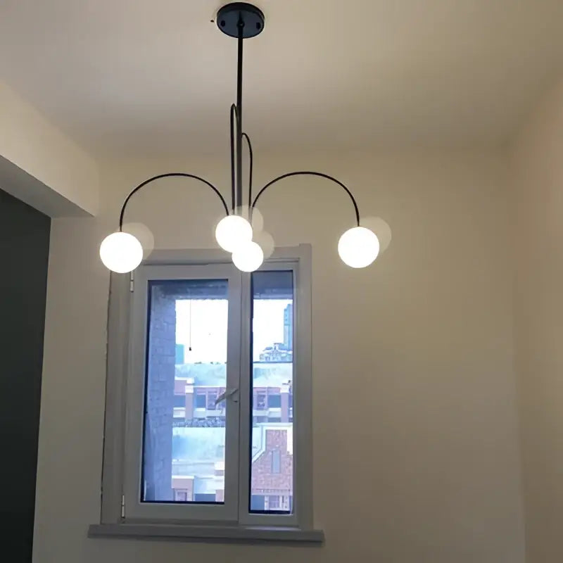 Black metal chandelier with five white globe lights showcasing decorbites branch glass pendant for living room decor