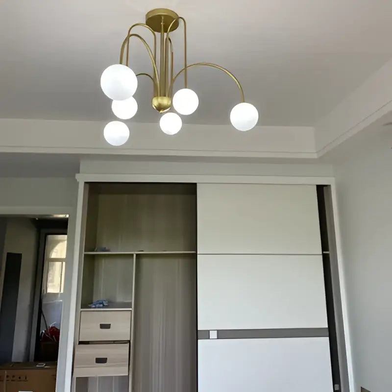Modern red and white branch glass pendant lights featuring a gold-toned chandelier with six white glass globes for living room decor