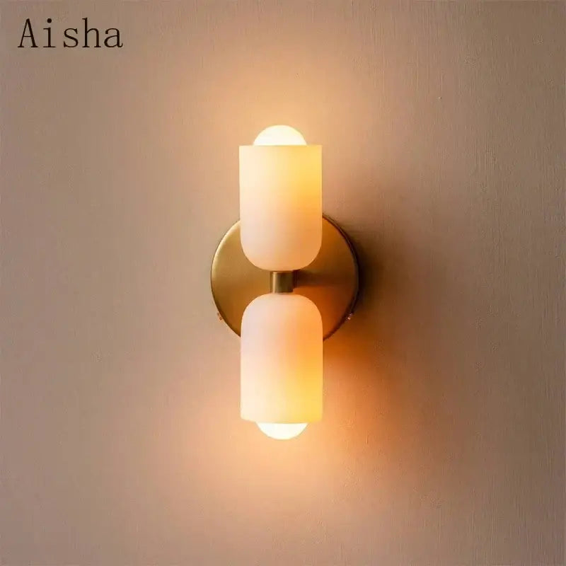 Modern red and white double head glass wall light with frosted glass cylinders on brass base for bedroom use