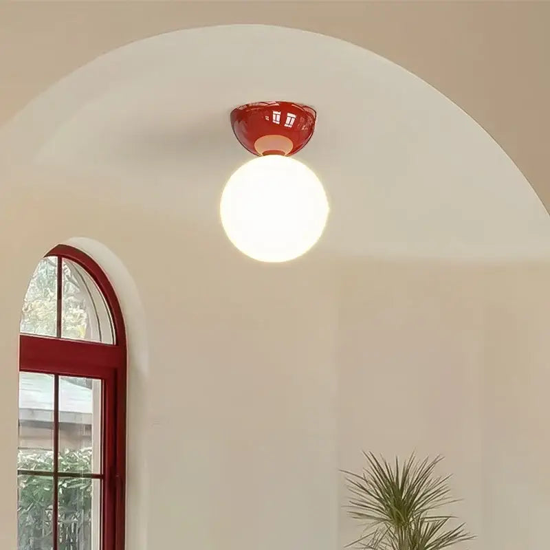 Modern red and white iron glass led ceiling light with a red ceramic base and round white globe bulb by decorbites iron glass