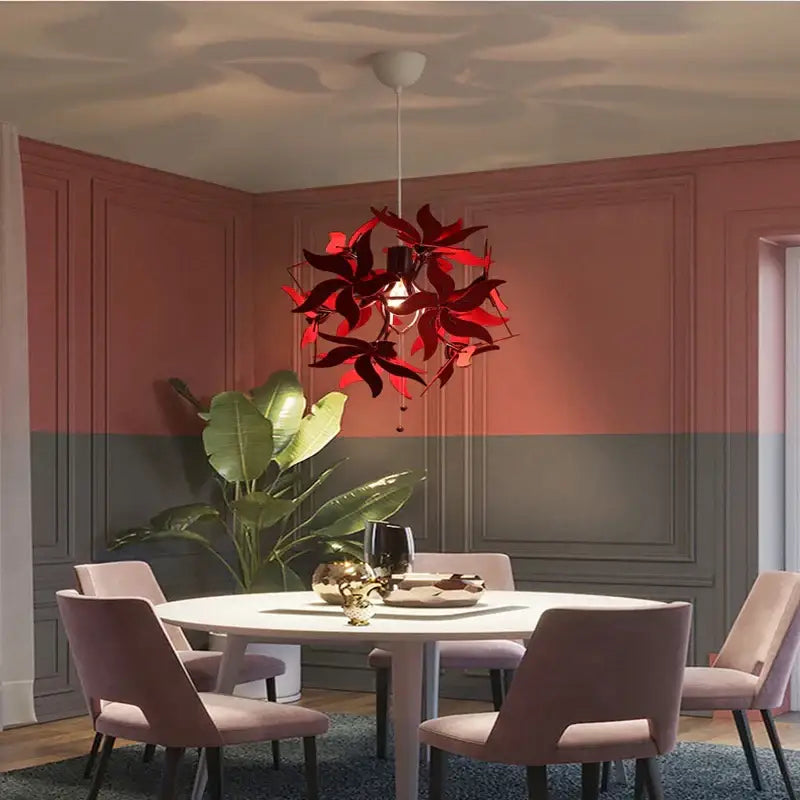 Vibrant red metallic bauhinia flower chandelier with leaf-shaped pendant light fixture hanging above dining table