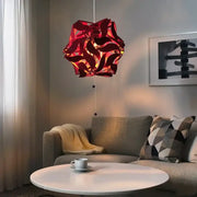 A vibrant red modern bauhinia flower chandelier with geometric translucent design hanging above a coffee table