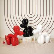 Three glossy balloon dog sculptures in red black and white modern decor for living room display