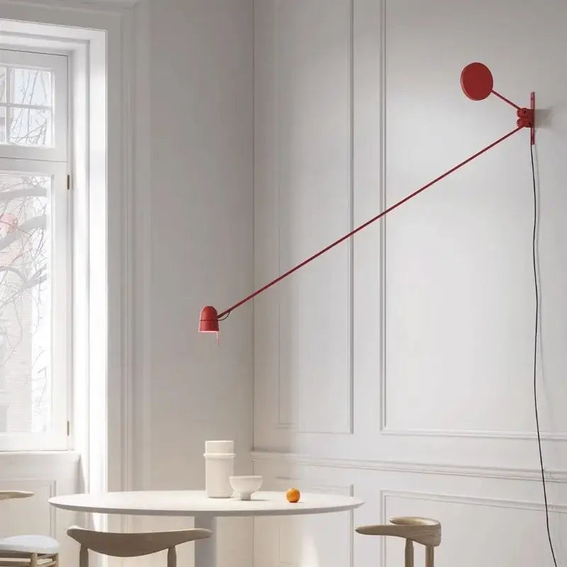 A sleek modern red and black swing arm wall sconce with an adjustable led circular head for bedroom lighting decorbites