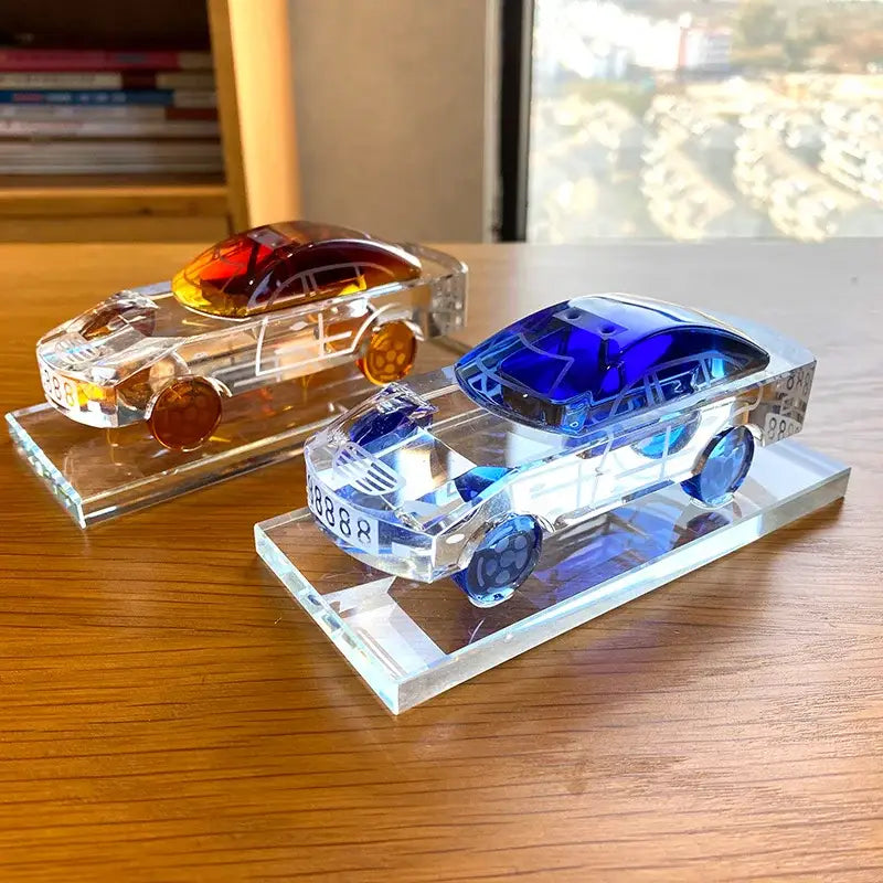Modern red and blue crystal car model with translucent bodies and vibrant roofs on clear acrylic bases for office decor