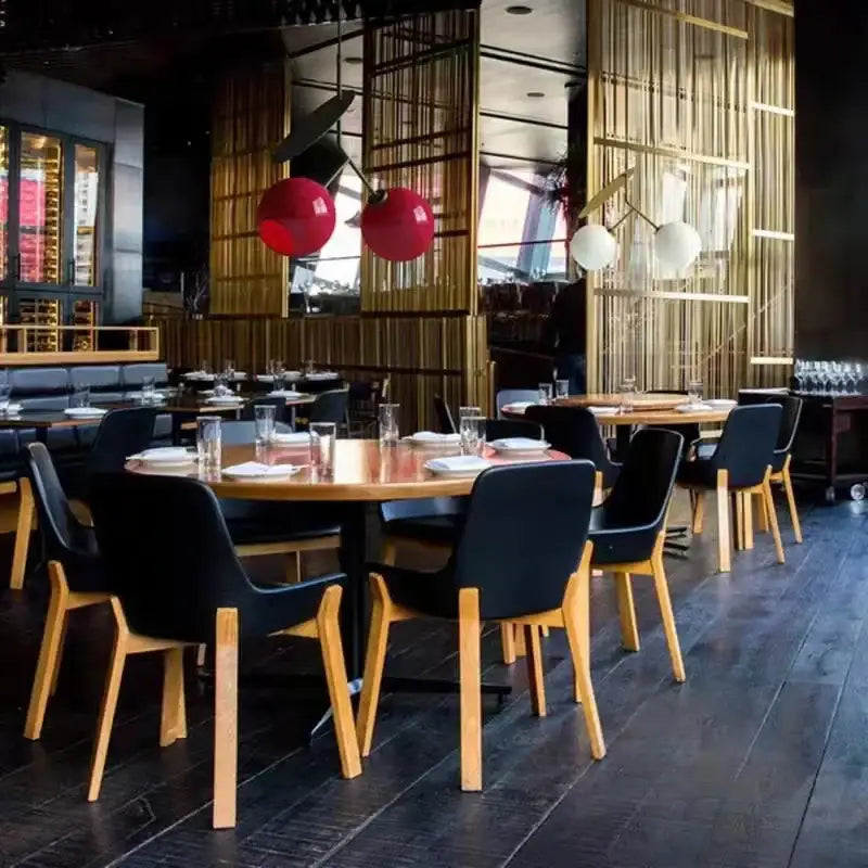 Black chairs with light wood legs arranged around wooden tables under a modern red decorbites cherry led pendant light fixture