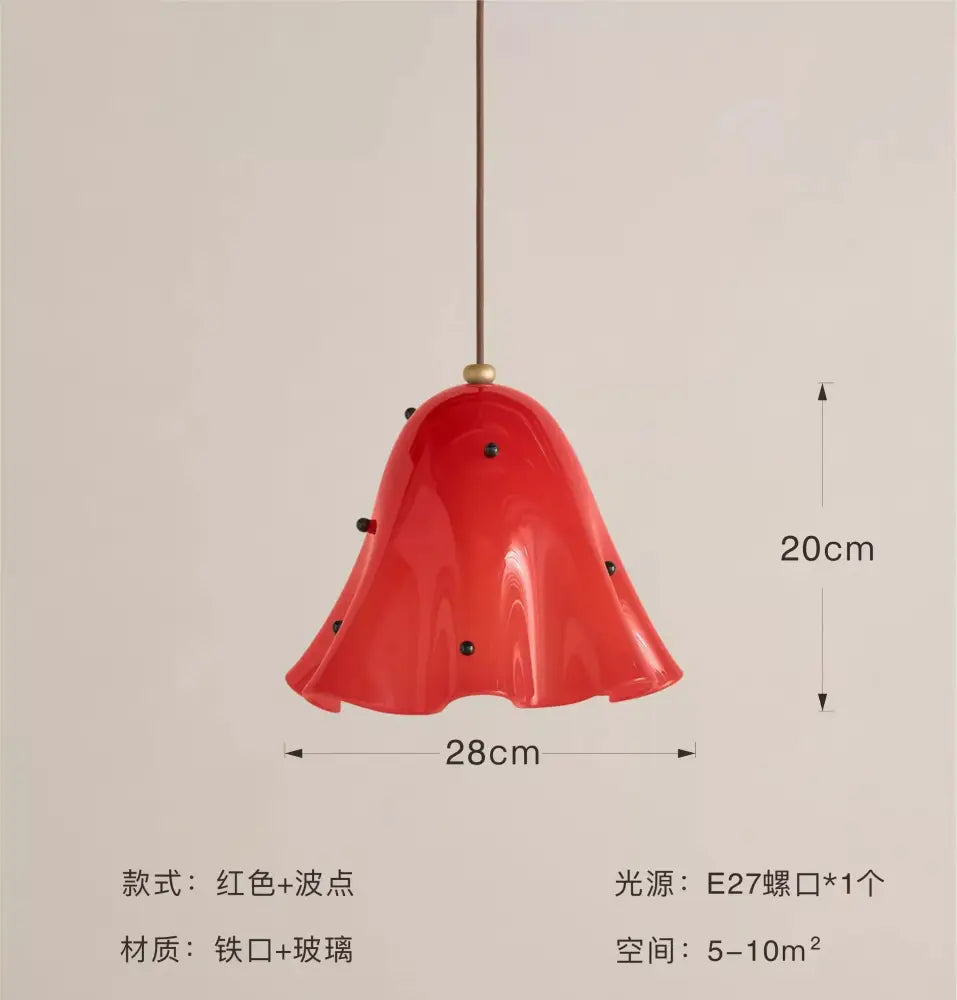 Modern red glass pendant light with black dots featuring a glossy finish and brass chain for dining room pendant lights