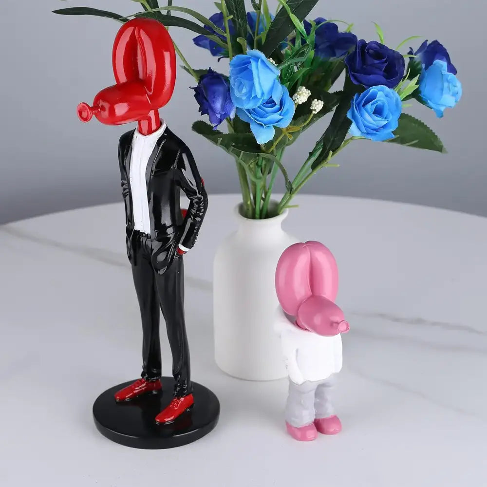 Red balloon dog statue figurine in glossy black suit with red shoes standing on circular base modern resin decor