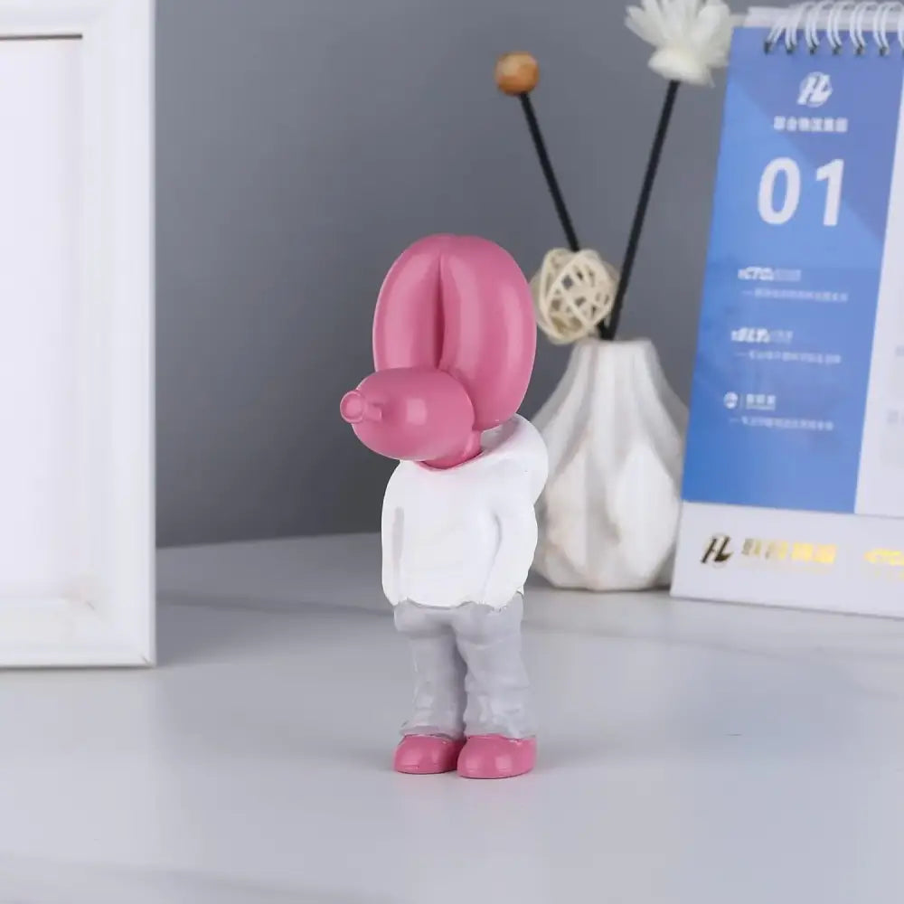 Pink glossy balloon dog statue resin figurine wearing white hoodie and gray pants for modern living room decor