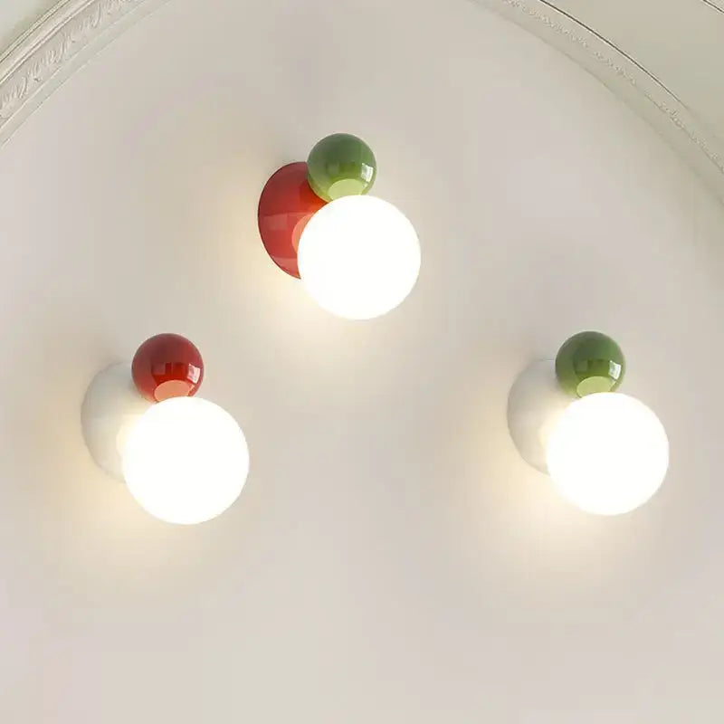 Three modern spherical led wall lights with glossy red and green acrylic accents for kids room decorbites led wall