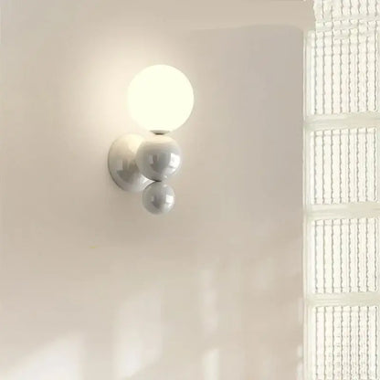 Modern red and green led wall light with white spherical acrylic shades featuring three stacked globes by decorbites led wall