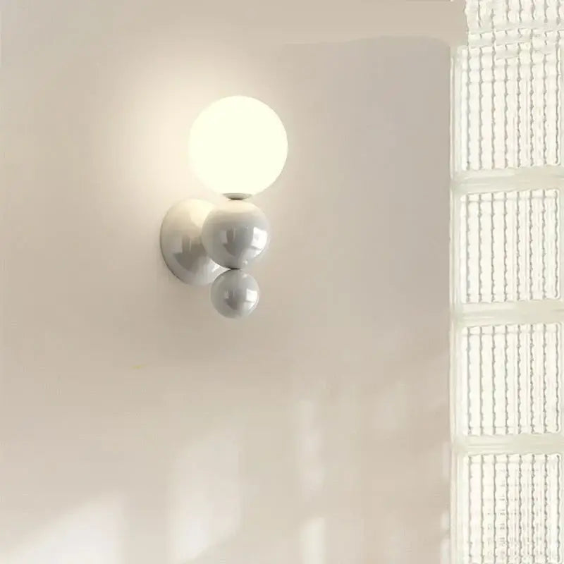 Modern red and green led wall light with white spherical acrylic shades featuring three stacked globes by decorbites led wall