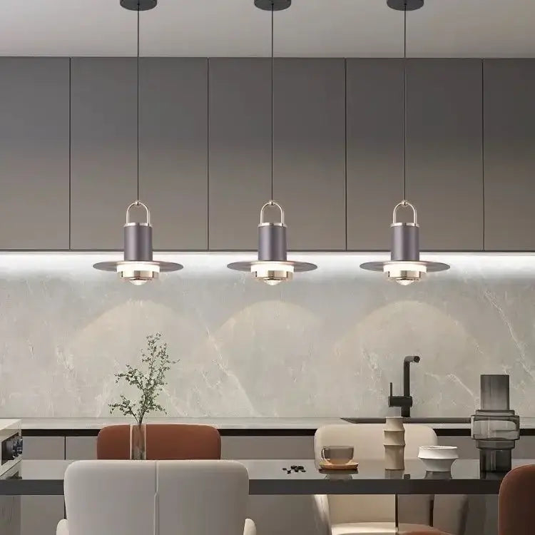 Three modern gray pendant lamps with matte cylindrical shades hang above a kitchen island for decorbites colorful umbrella pendant decor