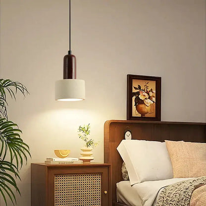 Modern reddish brown and cream decorbites cement cylinder led pendant with dark wood top and white shade hanging by black cord