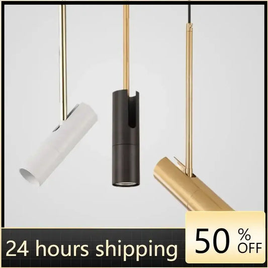 Three modern refined metal pendant lights with white black and gold cylindrical shades provide focused light