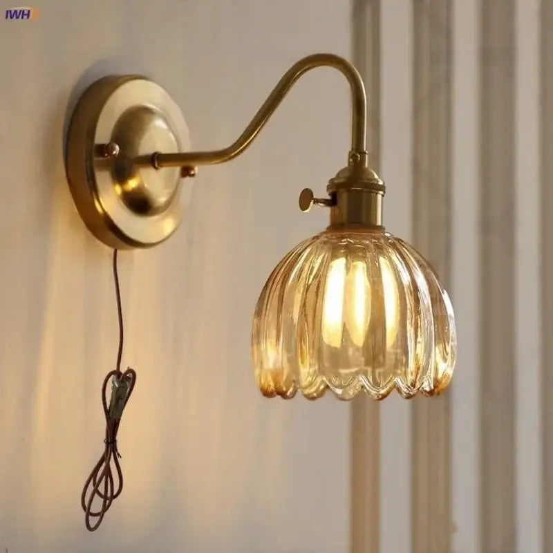 Brass wall sconce with ribbed amber glass shade and glass copper knob switch for modern bedroom lighting